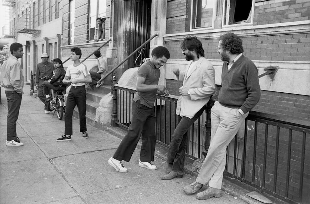 (Right-left) Diego Echeverria and Fernando Moreno speak with community members on a street in Los Sures.