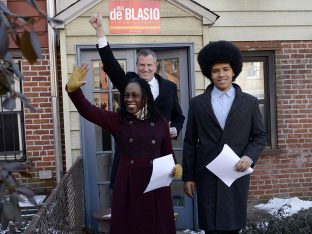 New York City Public Advocate Bill de Blasio waves to supporters with his wife Chirlane McCray and son Dante as they leave their house to announce his Democratic candidacy for mayor in the Brooklyn borough of New York