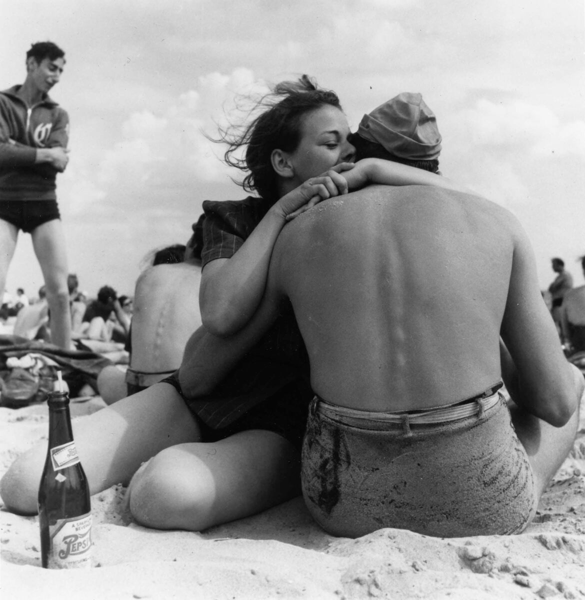 1938: A couple sitting embraces on a crowded beach. Coney Island, Brooklyn. New York, New York, 1938. 01/01/1938 Photo by Morris Engel/Getty Images