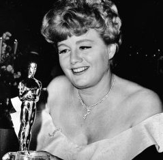 U.S. actress Shelley Winters, whose role in "A Patch of Blue" won her the 'Best Supporting Actress' Oscar at last night's Academy Awards, admires the Golden Statuette at an Academy party, Santa Monica, CA, April. 19, 1966. (AP Photo)